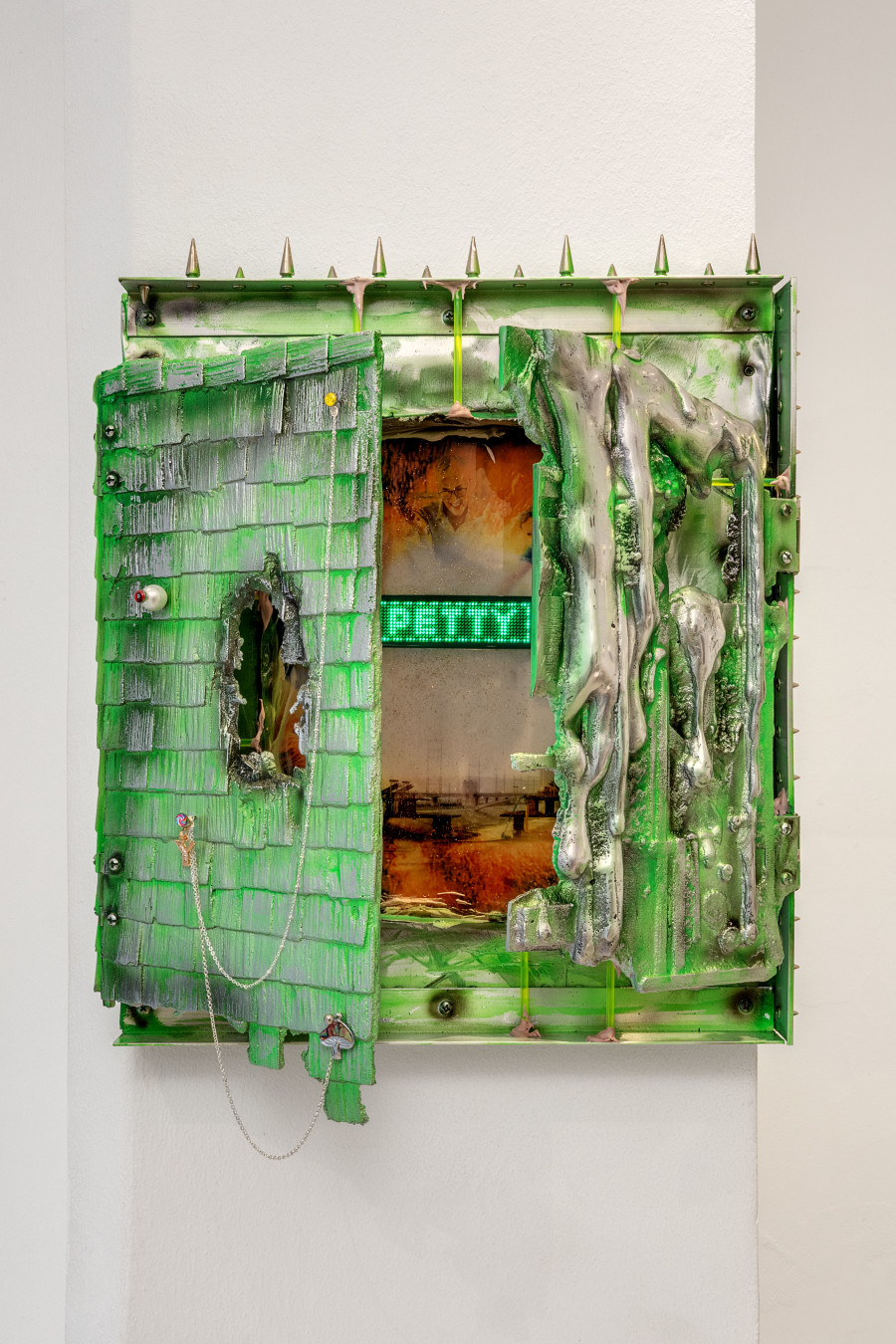 Mathis Altmann (*1987) Bridging Commerce III, 2019 Polished aluminum, airbrushed, inkjet print, LED name badge, resin, acrylic, vinyl spackling, studs, tongue piercings, silver chains, charms 41 x 36 x 8 cm (16.14 x 14.17 x 3.15 in)