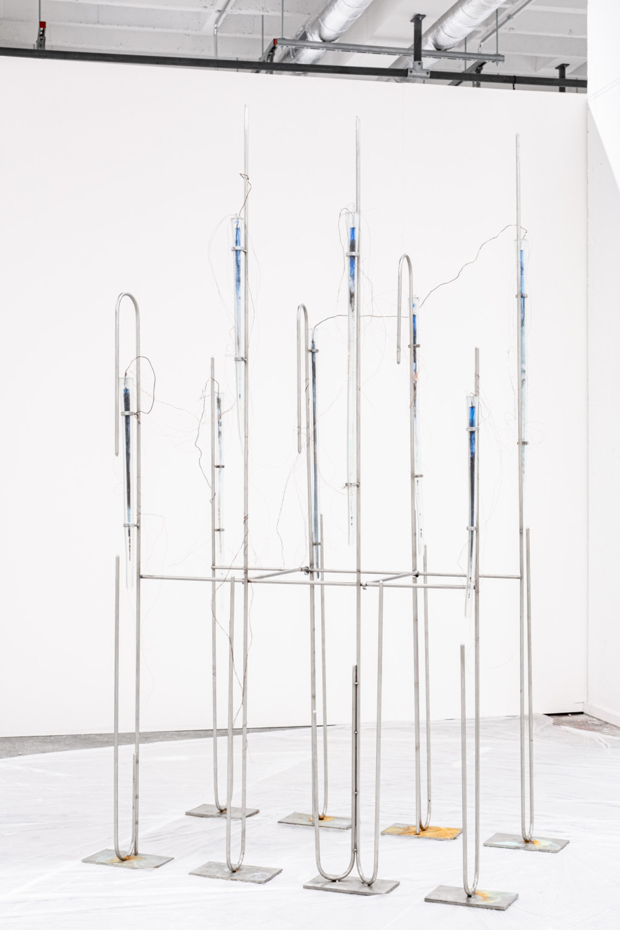 Exhibition View Group Show «Zahltag; view on Matheline Marmy, Retainer-Continuity, 2023, blown glass, stainless steel, copper wire, copper oxide, iron oxide, water, plastic sheet, 190 x 90 x 45 cm» at Le Commun, Geneva, 2024 / Photo: Daniel Leal / Courtesy: Spielact Festival