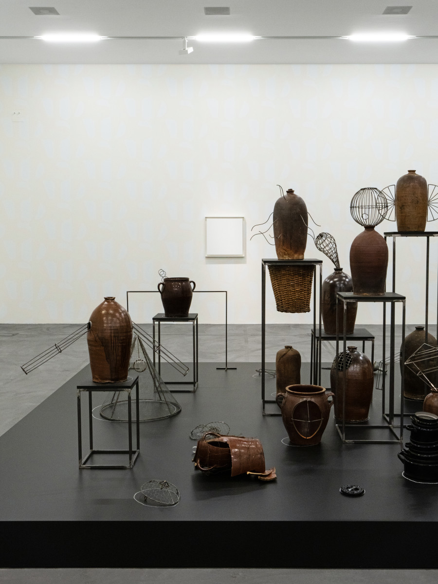 Eva Kot’átková, Collection of Suppressed Voices, 2014, Steel, fired clay, prints on paper, cardboard, chalk, baskets, wood, General Idea, White AIDS (Wallpaper), 1990, Screen print on paper and White AIDS (F), 1993, Tinted white acrylic gesso (3 tints) on canvas, Sammlung Migros Museum für Gegenwartskunst. Exhibition view Migros Museum für Gegenwartskunst, Photo: Studio Stucky © Eva Kot’átková, General Idea