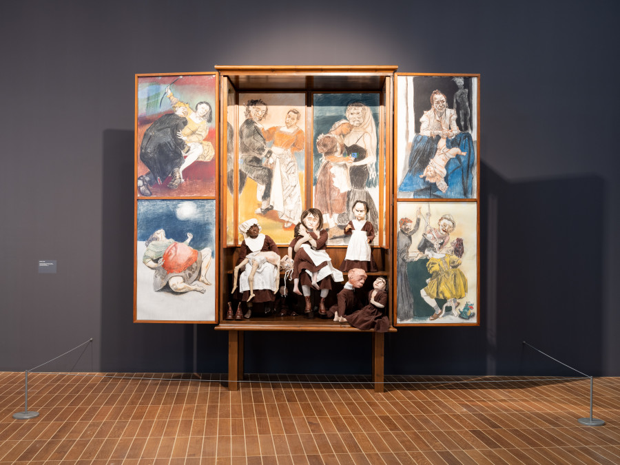 Exhibition view, Paula Rego, Power Games, Kunstmuseum Basel, 2024-2025. Oratório, Paula Rego, 2009, Holzschrank mit Seitenteilen, auf einem 48 cm hohen Sockel, mit acht gerahmten Bildfeldern mit verschiedenen Malmaterialien auf Papier und acht Kostümfiguren, 332 x 349 x 81.9 cm. © Paula Rego. All rights reserved 2024 / Bridgeman Images. Courtesy Ostrich Arts Ltd and Victoria Miro. Photo credit: Jonas Schaffter.