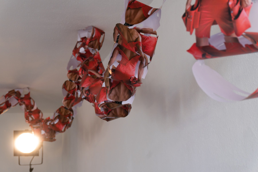 Exhibition view, Sven Gex, celebratory, Halmet, Zürich, 2025. Sven Gex, garland for ‚celebratory‘ (maid-of-all-work character), 2025, hand cut printed pictures, staples