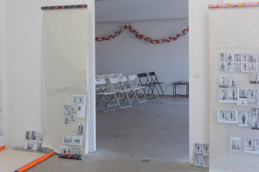 Exhibition view, Sven Gex, celebratory, Halmet, Zürich, 2025. From left to right: Sven Gex, celebratory, 2025, gift wrapping paper, nails, glass, printed images from the ‚character fitting‘ series 2021-ongoing ; Sven Gex, garland for ‚celebratory‘ (maid-of-all-work character), 2025, hand cut printed pictures, staples ; Sven Gex, celebratory, 2025, gift wrapping paper, nails, glass, printed images from the ‚character fitting‘ series 2021-ongoing