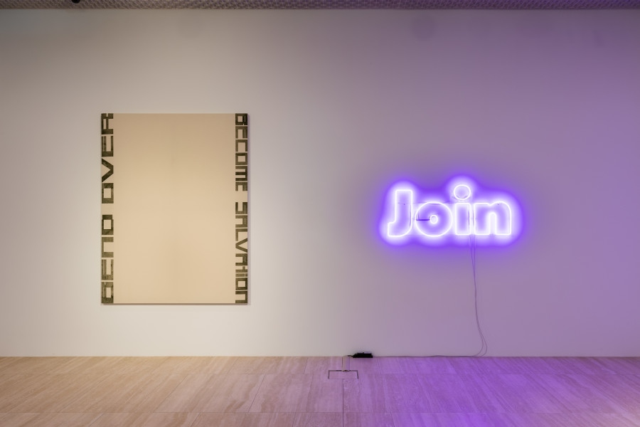 Left: Marlene McCarty, Untitled (Bend Over Become Salvation), 1993, Heat Transfer on Canvas, 198 x 152 cm Private collection, Switzerland.  Right: Mitchell Anderson, Join (the Great Peace March (Keith Haring, 1986)), 2023, Neon, glass, 55 x 130 cm. Photo: Kilian Bannwart