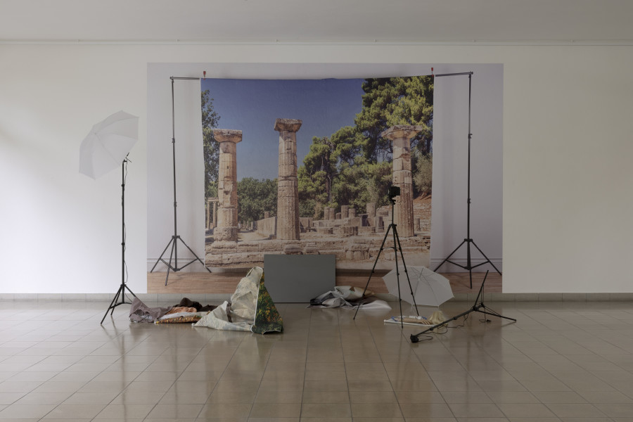 John Miller, Epic Theater, 2020, Print, Beleuchtungsständer, Kameraständer, Kamera, Stoff, Perücke, Studioleuchte Schirme, Schaufensterpuppen-Hand und -Fuss, graue Farbe auf Leinwand / Print, lighting stand, camera stand, camera, fabric, wig, studio light shades, mannequin hand, mannequin foot, gray paint on canvas. Dimension der Installation variabel / installation dimensions variable. Courtesy Sammlung / Collection MAMCO, Genf / Geneva. Anonyme Schenkung / Anonymous donation. Photo: Gina Folly