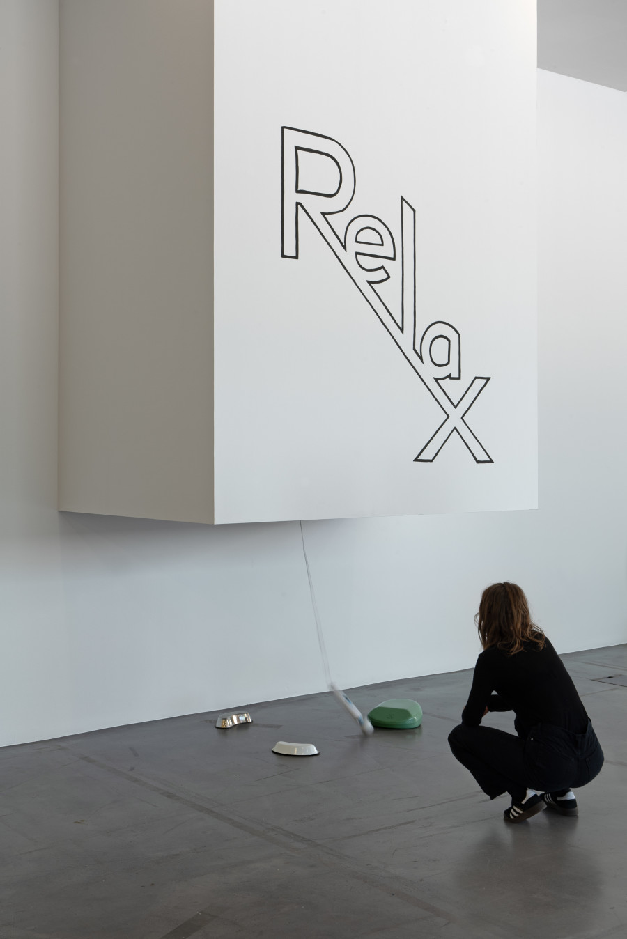 Exhibition viewInterdependencies: Perspectives on Care and Resilience, Ezra Benus, Relax (erotic hypnosis), 2023, Bed pans, Magic Wall, ‹Relax› painted on wood. Courtesy the artist. Photo: Studio Stucky